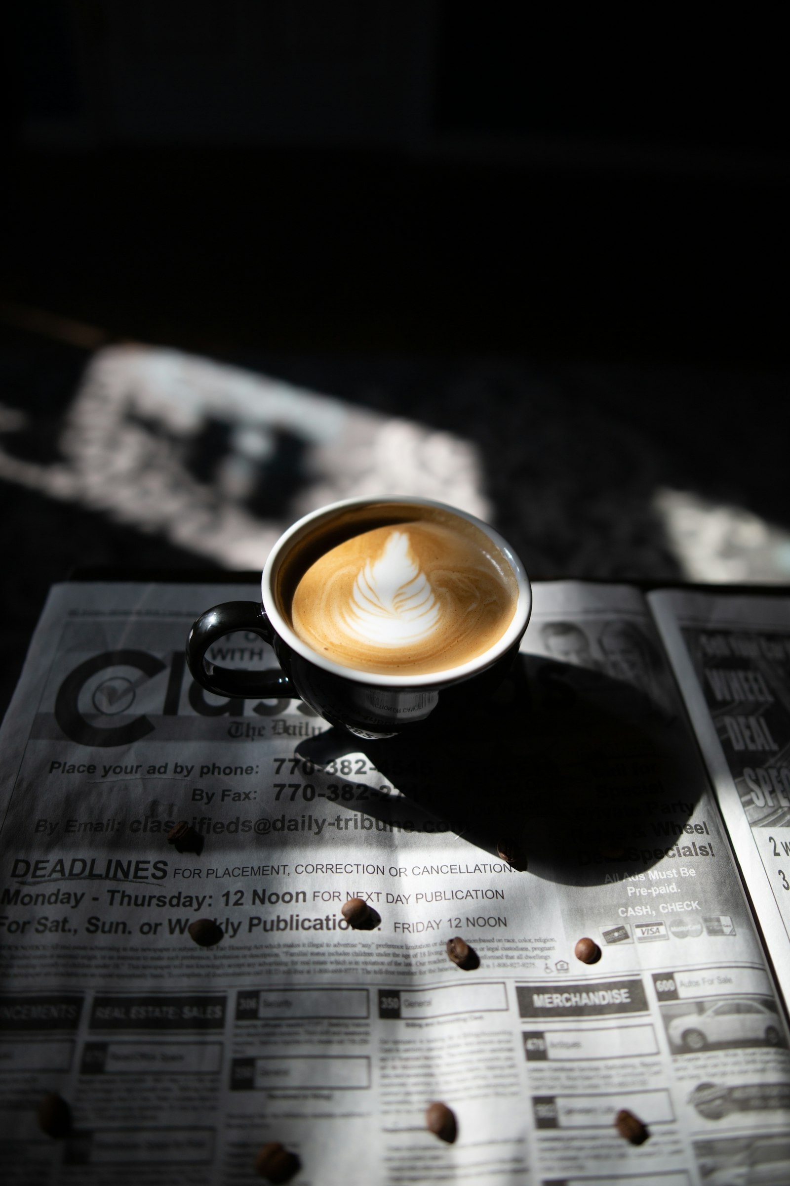 Close-up of intricate latte art in a dark ceramic cup